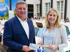 Bayerns Bauminister Christian Bernreiter übergibt Bundesbauministerin Verena Hubertz eine Maurerkelle bei der 146. Sonder-Bauministerkonferenz am 13. September 2025 in Berlin. Foto: StMB 